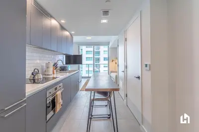 a kitchen with white cabinets and a wooden counter top at Downtown Miami Condos by Lua Host in Miami