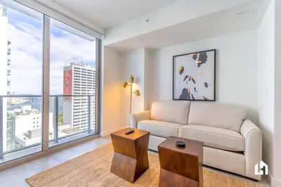 a living room with a couch and a large window at Downtown Miami Condos by Lua Host in Miami