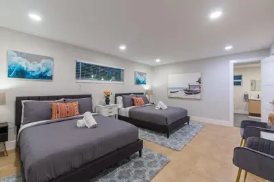 a bedroom with two beds and a living room at Super Fun Villa Game Room BY THE GLAMHOMES in North Miami Beach