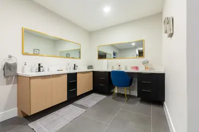 a bathroom with two sinks and a blue chair at Super Fun Villa Game Room BY THE GLAMHOMES in North Miami Beach