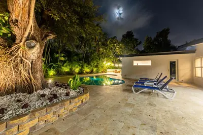 a backyard with a pool and a tree at Super Fun Villa Game Room BY THE GLAMHOMES in North Miami Beach