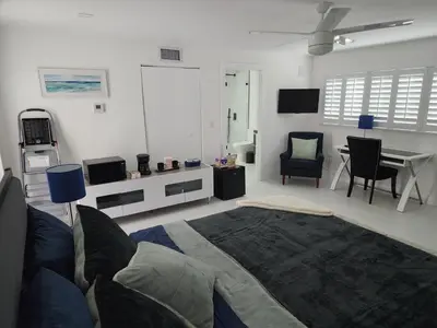 a living room with a bed and a dining room at JBMANORS in Fort Lauderdale