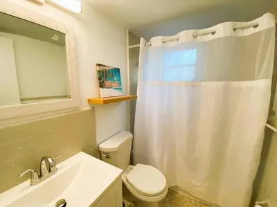 a bathroom with a white shower curtain and a toilet at Cozy Apartment Near Brickell in Miami