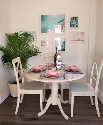 a dining room table with two chairs and a table with pink plates at Lovely Apartment Near Brickell 1 in Miami