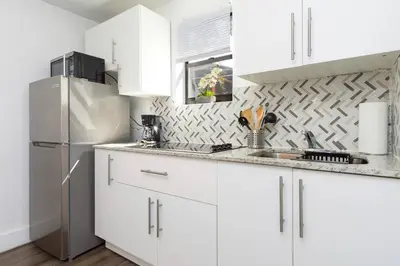 a white kitchen with white cabinets and a refrigerator at Lovely Apartment Near Brickell 1 in Miami
