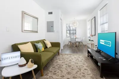 a living room with a green couch and a tv at Lovely Apartment Near Brickell 2 in Miami