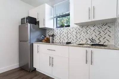 a kitchen with white cabinets and a stainless steel refrigerator at Lovely Apartment Near Brickell 2 in Miami