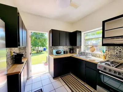 a kitchen with black cabinets and a large window at Tropical Charm Little Havana Calle Ocho 3 in Miami