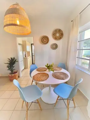 a dining room with a white table and blue chairs at Tropical Charm Little Havana Calle Ocho 2 in Miami