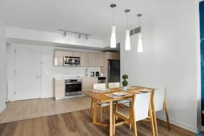 a kitchen and dining room with a table and chairs at Apartment w Balcony Gym Near Beach in Hallandale Beach
