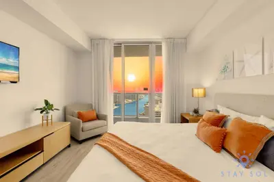 a bedroom with a bed and a desk and a window at Infinite View Balcony Pool Gym in Hallandale Beach