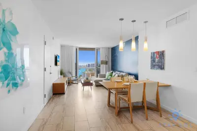 a dining room and living room with a table and chairs at Infinite View Balcony Pool Gym in Hallandale Beach