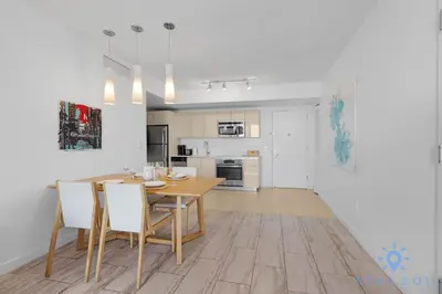 a kitchen and dining room with a wooden table and chairs at Infinite View Balcony Pool Gym in Hallandale Beach