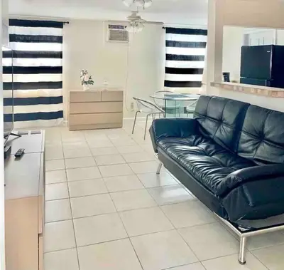a living room with a black leather couch and a table at Private Room near Miami Airport - Free parking - 02 in Miami
