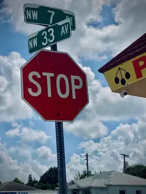 a stop sign with street signs on top of it at Private Room near Miami Airport - Free parking - 02 in Miami