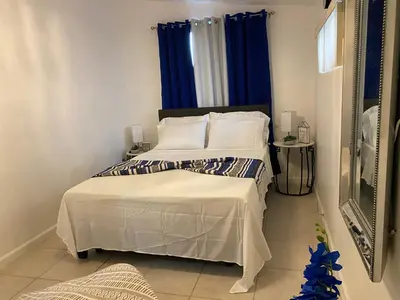 a bedroom with a large bed with blue curtains at Beautiful House 7 min from Miami Airport w FREE parking in Miami