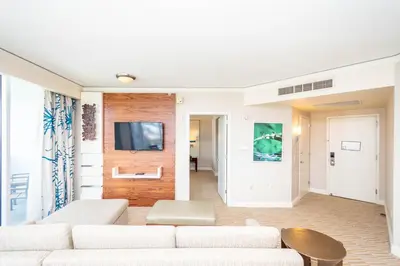 a living room with a couch and a tv on a wall at TRUMP INTERNATIONAL BEACH RESORT 2 BEDROOM APARTMENT 1600 Sf Ocean and Bay View in Miami Beach