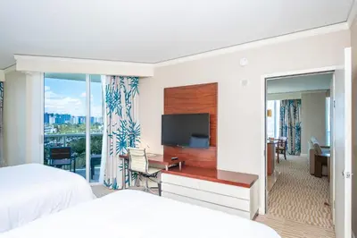 a hotel room with a bed and a desk with a television at TRUMP INTERNATIONAL BEACH RESORT 2 BEDROOM APARTMENT 1600 Sf Ocean and Bay View in Miami Beach