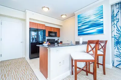 a kitchen with a counter and two chairs and a refrigerator at TRUMP INTERNATIONAL BEACH RESORT 2 BEDROOM APARTMENT 1600 Sf Ocean and Bay View in Miami Beach
