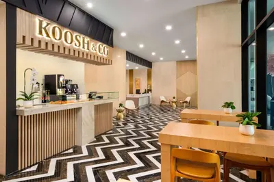a restaurant with tables and chairs and a kostesis cafe at Dolce by Wyndham Hollywood in Hollywood