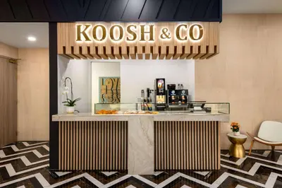 a lobby with a kogi and co counter with chairs at Dolce by Wyndham Hollywood in Hollywood