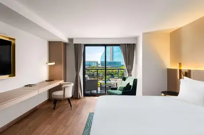 a hotel room with a bed and a desk and a window at Dolce by Wyndham Hollywood in Hollywood
