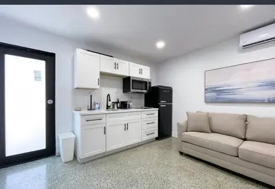 a living room with a couch and a kitchen at Private King Suite in Miami in Miami