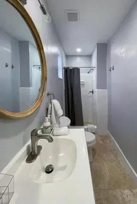a bathroom with a sink and a mirror and a toilet at Private King Suite in Miami in Miami