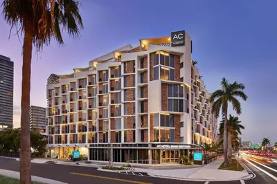 a building on a city street with palm trees at AC Hotel Miami Wynwood in Miami