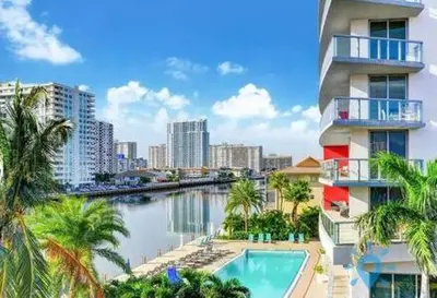 a building with a swimming pool next to a river at Upper studio Balcony Pool Gym - Near Beach in Hallandale Beach