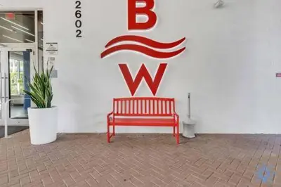 a red bench in front of a wall with the letter w at Upper studio Balcony Pool Gym - Near Beach in Hallandale Beach