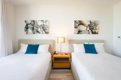 two beds sitting next to each other in a room at Infinite View Balcony & Pool Gym Near Beach in Hallandale Beach