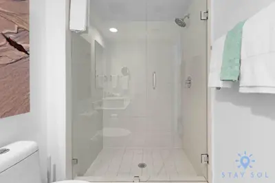 a white bathroom with a shower and a toilet at Infinite View with Balcony and Resort, Pool, Gym in Hallandale Beach