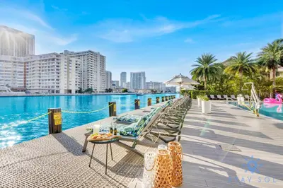 a resort with a pool with chairs and a table at Infinite View Balcony Pool in Hallandale Beach