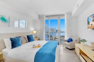 a bedroom with a large bed with a view of the ocean at Pool - Apartment with Balcony - Gym - Near Beach in Hallandale Beach