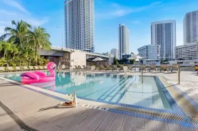 a large swimming pool in a city with tall buildings at Pool - Apartment with Balcony - Gym - Near Beach in Hallandale Beach