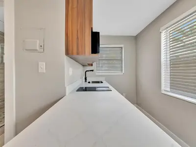 a kitchen with white walls and a white counter at The Shell on Walnut Studio Hollywood Beach Free Parking in Dania Beach