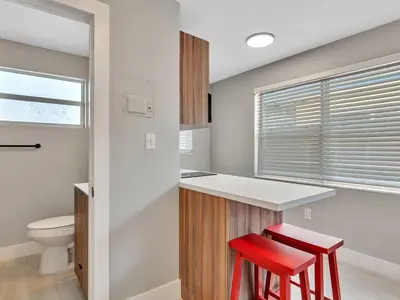 a bathroom with a toilet and two red stools at The Shell on Walnut Studio Hollywood Beach Free Parking in Dania Beach