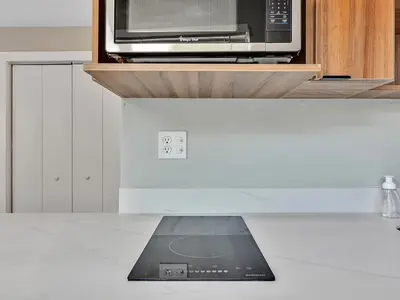 a laptop sitting on a counter under a microwave at The Shell on Walnut Studio Hollywood Beach Free Parking in Dania Beach