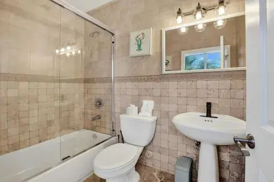 a bathroom with a toilet and a sink and a tub at Hot Tub! Roof Top! Firepit! Boat Dock! in Fort Lauderdale