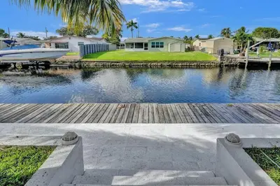 a dock with a boat on a body of water at Hot Tub! Roof Top! Firepit! Boat Dock! in Fort Lauderdale