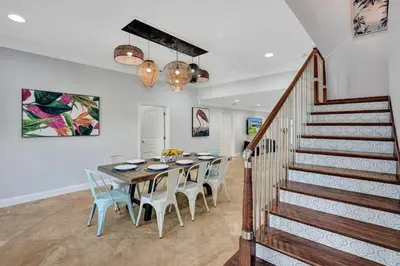 a dining room with a table and chairs and a staircase at Hot Tub! Roof Top! Firepit! Boat Dock! in Fort Lauderdale