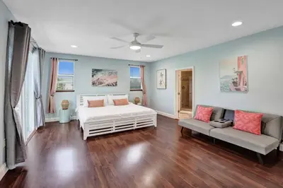a bedroom with a white bed and a couch at Hot Tub! Roof Top! Firepit! Boat Dock! in Fort Lauderdale