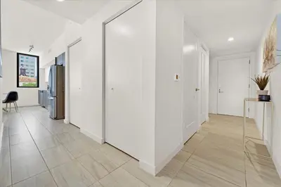 a hallway with white walls and tile floors and a refrigerator at Devereaux Miami Luxury One-Bedroom and Studios in Miami