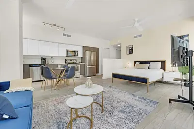 a living room with a couch and a bed and a kitchen at Devereaux Miami Luxury One-Bedroom and Studios in Miami