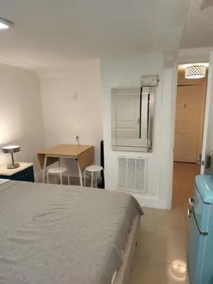 a bedroom with a bed and a table and a table at 1161 Studio 2 Miami in Tamiami