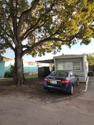 a car parked under a tree next to a trailer at 1161 Studio 2 Miami in Tamiami
