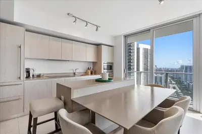 a kitchen with a table and chairs and a large window at Ocean Views Perfect Location Resort Amenities in Hallandale Beach