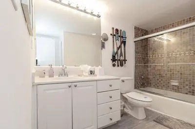 a bathroom with a sink and a toilet and a tub at Stunning & Spacious Resort-Style Condo Across From Beach! in Miami Beach