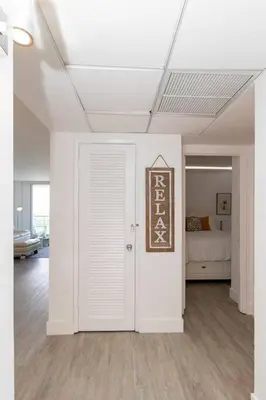 a white room with a bed and a door at Stunning & Spacious Resort-Style Condo Across From Beach! in Miami Beach